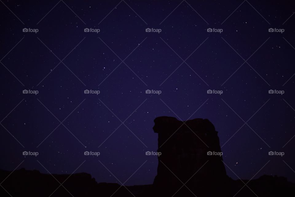 Stars and a colorful night sky in Arches National Park on a clear spring night. Stars light up the sky. Natural features.