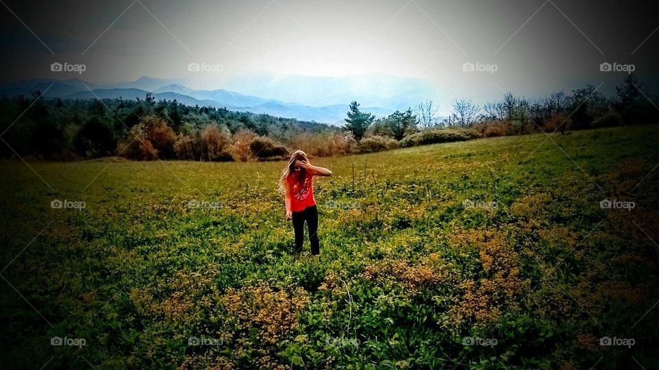 Girl in field on mountain.
