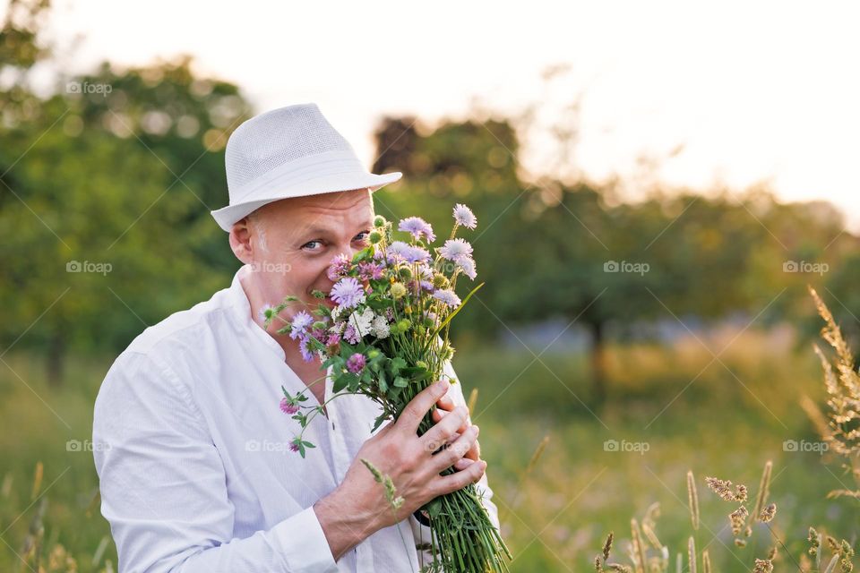 A nice man with a bouquet of wild flowers