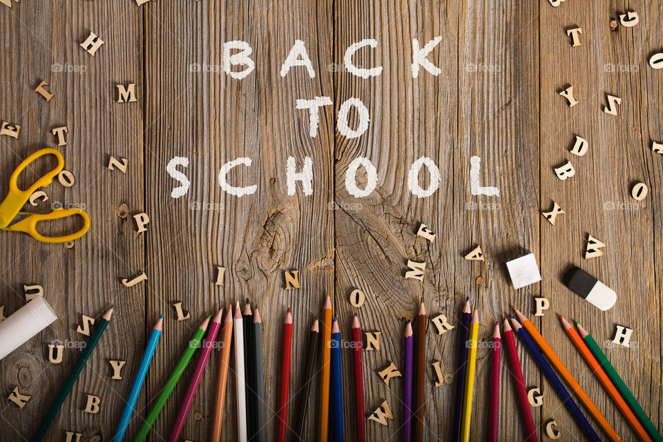 Back to school background. Pencils, letters on the wooden surface