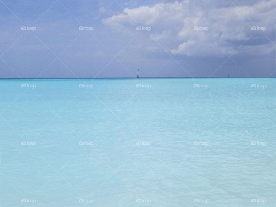 Beautiful neon baby blue carribean waters off the coast of Antigua beach.