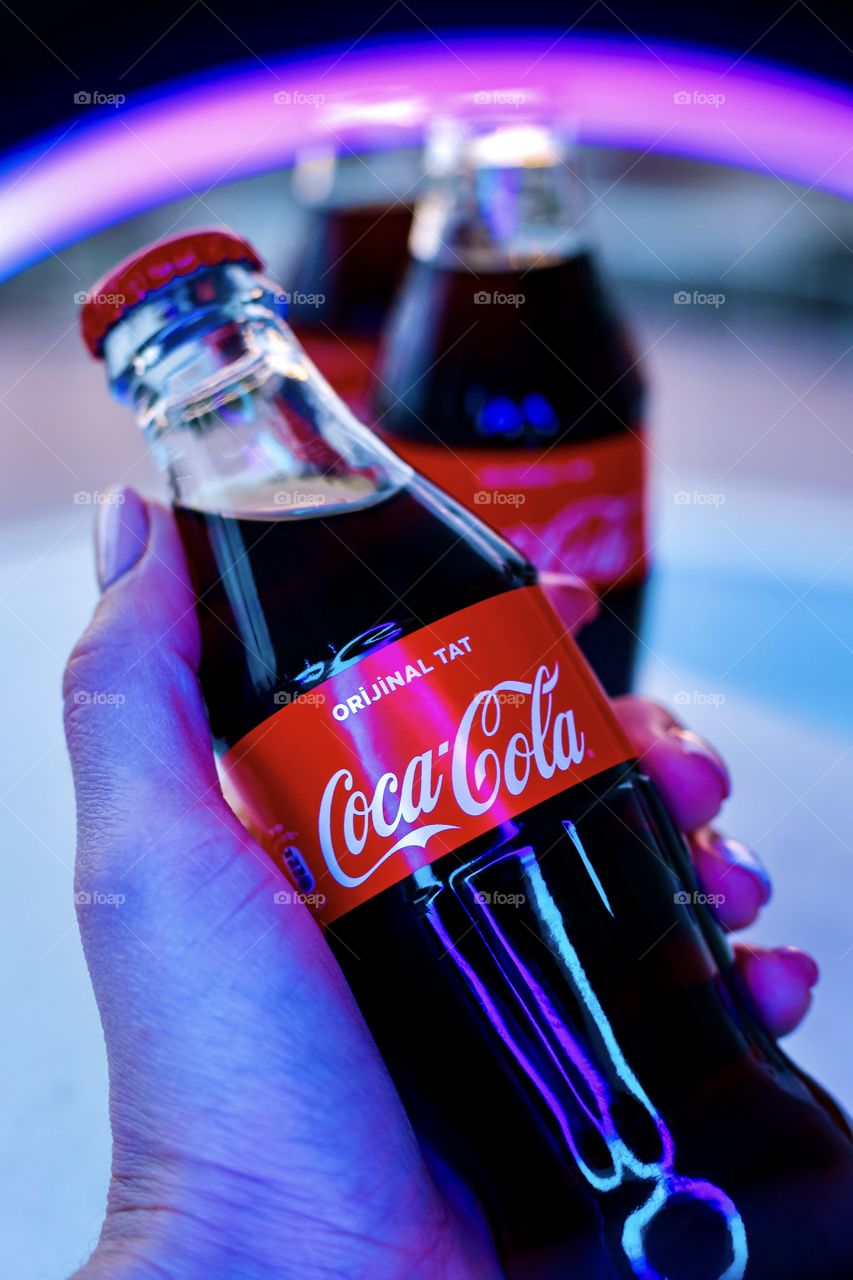 Bottle of Coca Cola in hand