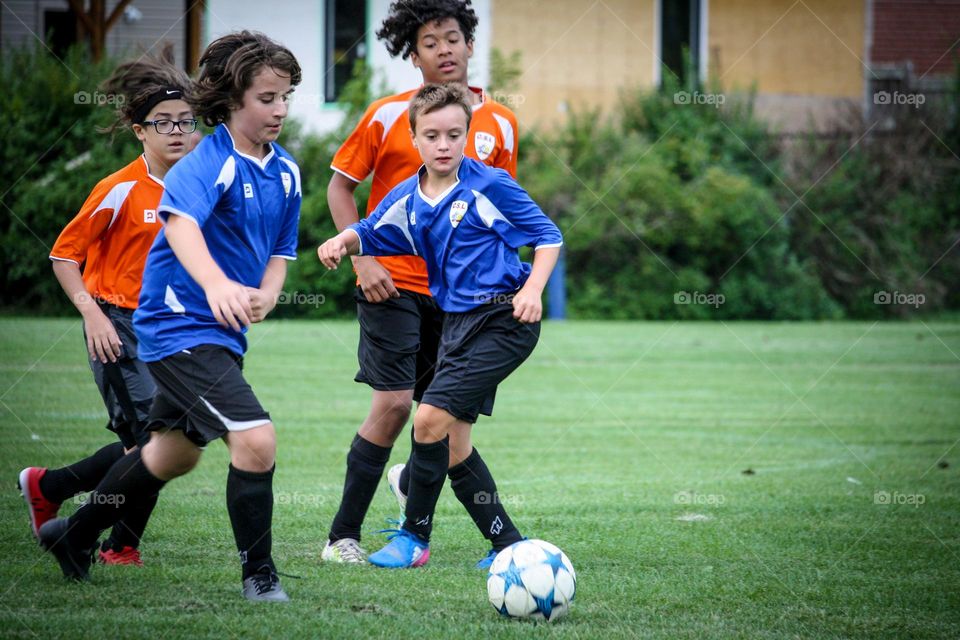 Kids are playing soccer in summer