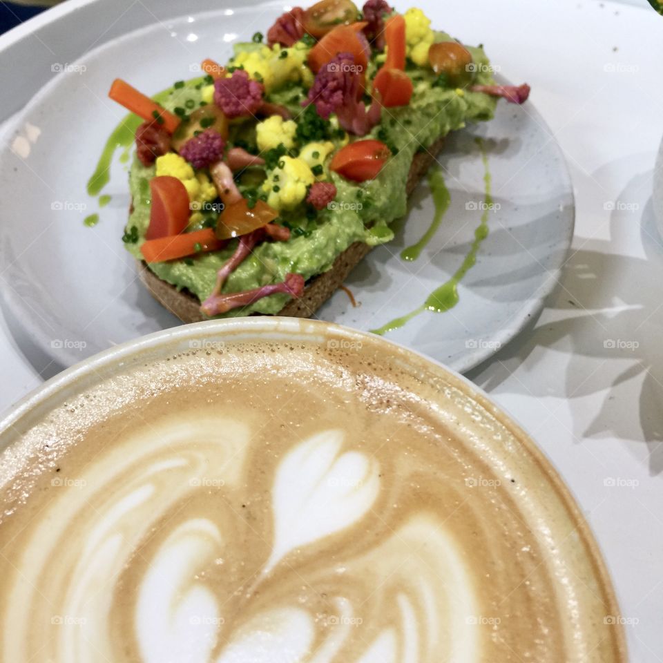 Latte art with decked out avocado toast