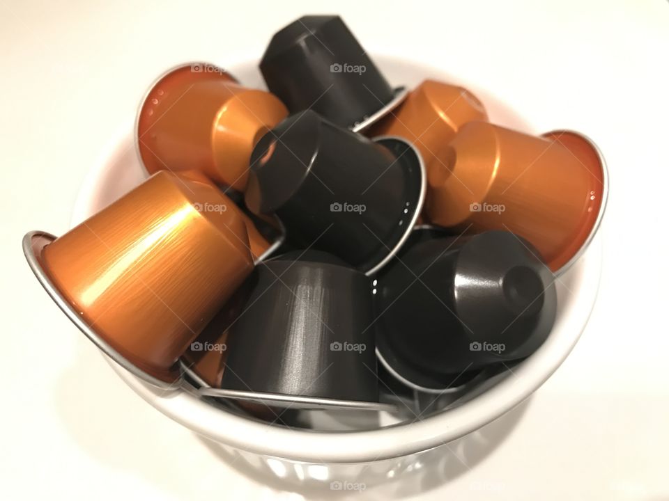 Orange and black coffee capsules on white background 