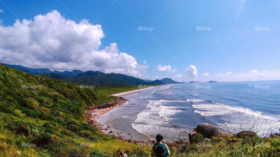 Beautiful Brazilian Beach, at Ilha do Cardoso, Cananéia. Long Beach, sunny day and people hiking in the mountains.