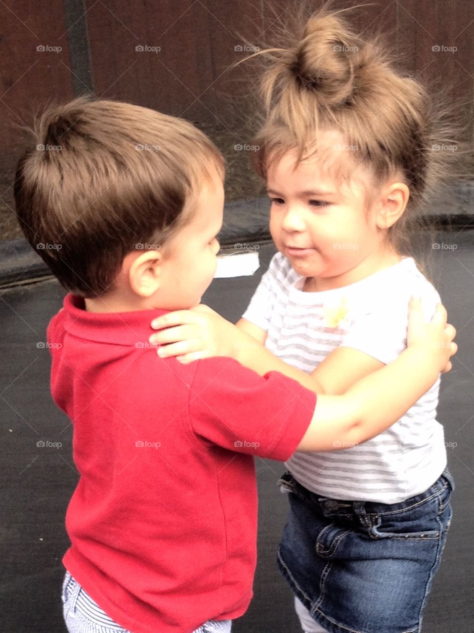 BEST friends share a hug during play time girl & boy age 2
