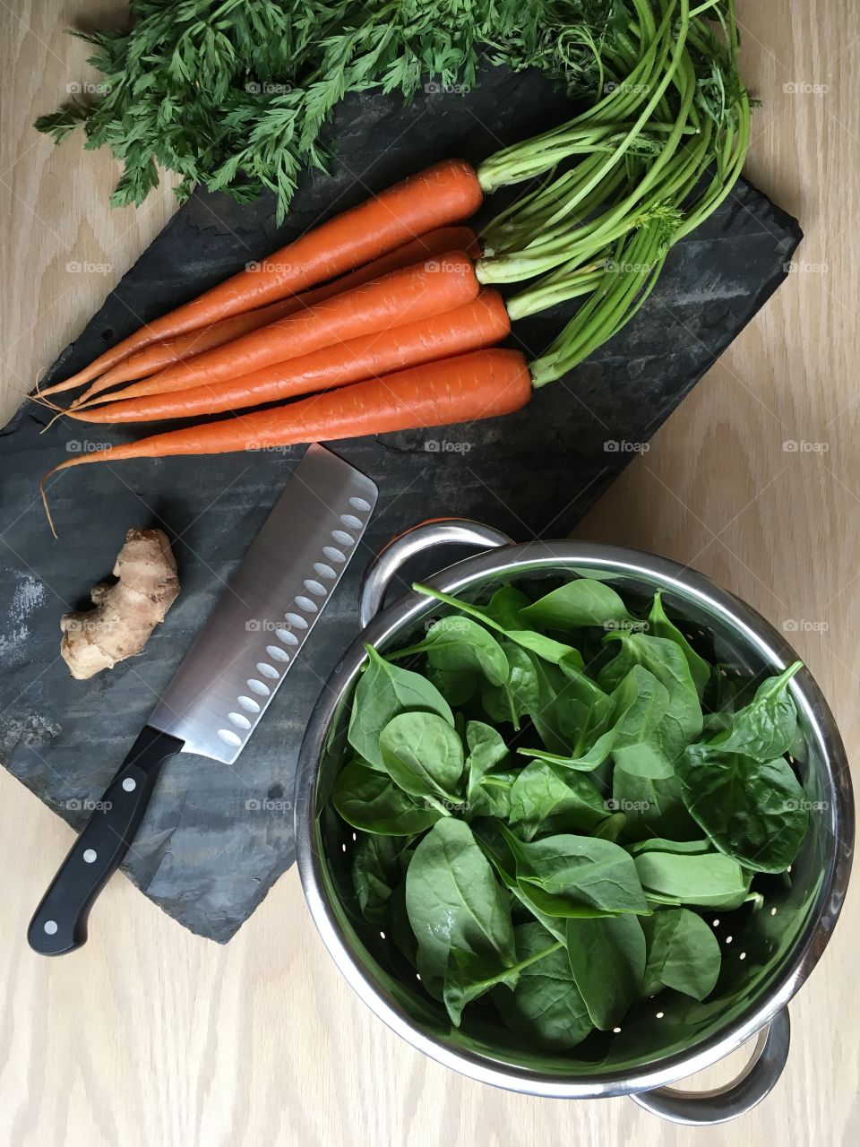 Cooking with fresh vegetables; baby spinach, organic carrots, ginger root. Healthy spring time meals.