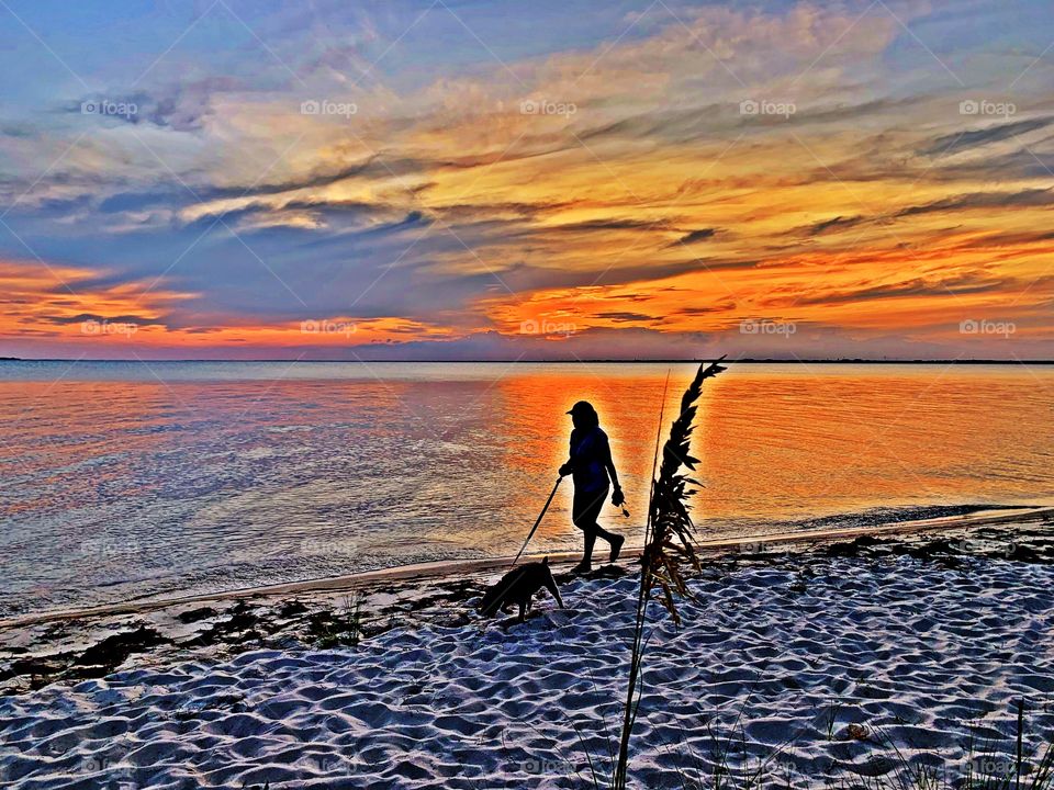 A women walks her dog during the last light of the day