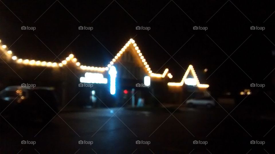dreamy blurry view of a Christmas light shop strip