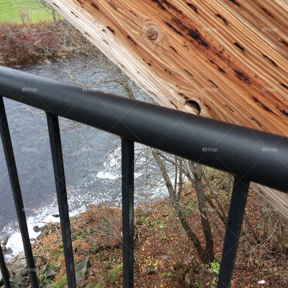 Wooden and steel rail walking bridge across a river