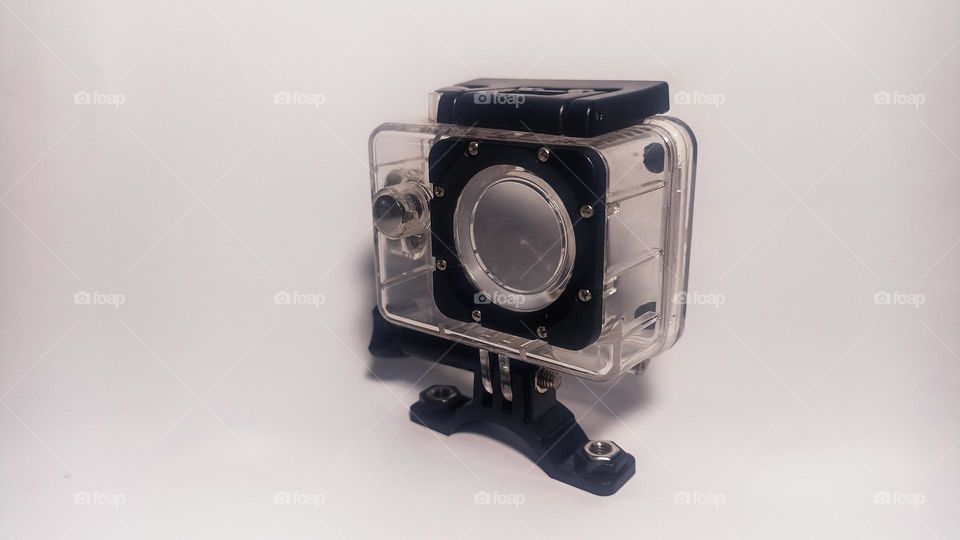 Small waterproof camera and cover on isolated white background in eye level view