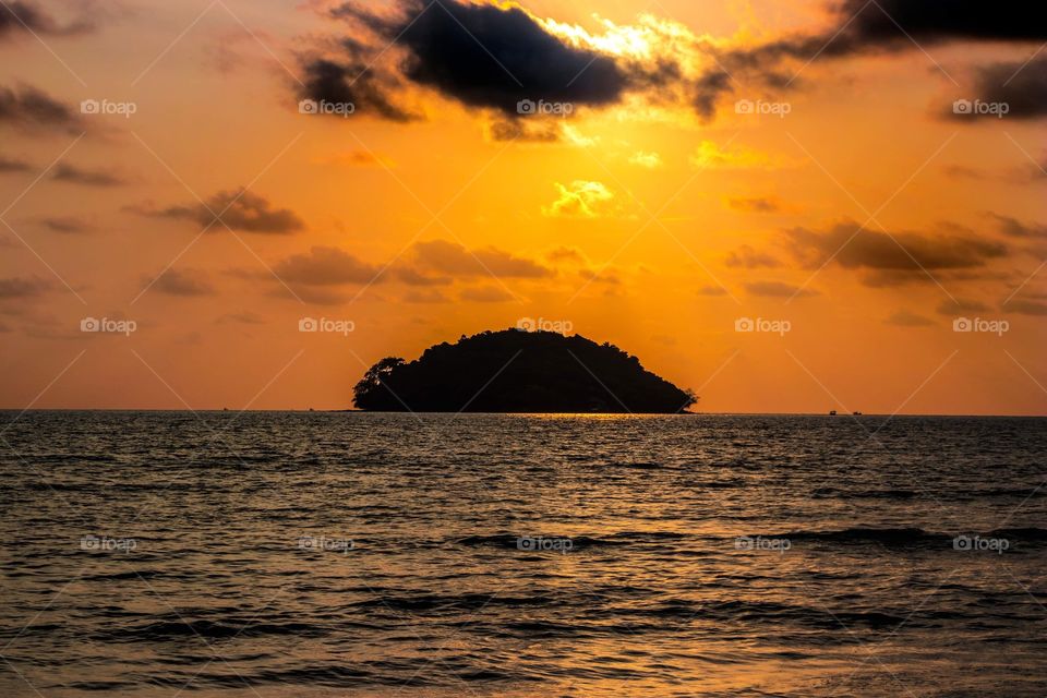 An orange sunset over a small island in Sihanoukville, Cambodia.