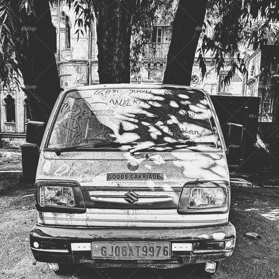 Black and white vehicle, vehicle needs a bath, abandoned vehicles in India, writing on a vehicle, dirty cars in monochrome 