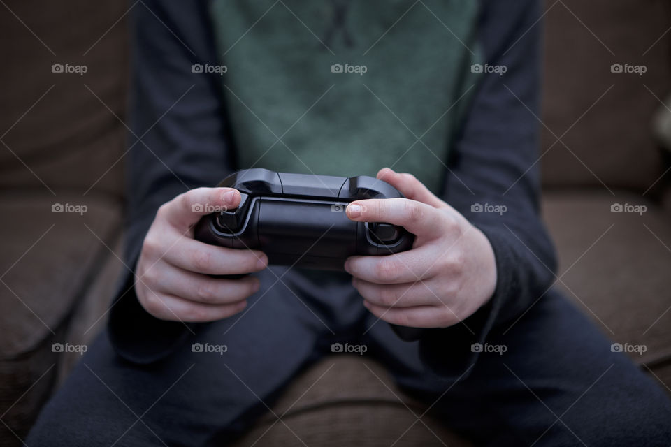 Young Caucasian boy holding video game controller. 