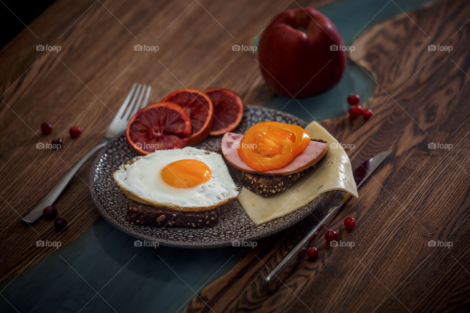 Sandwiches with fried egg orange tomato and red orange fruit 