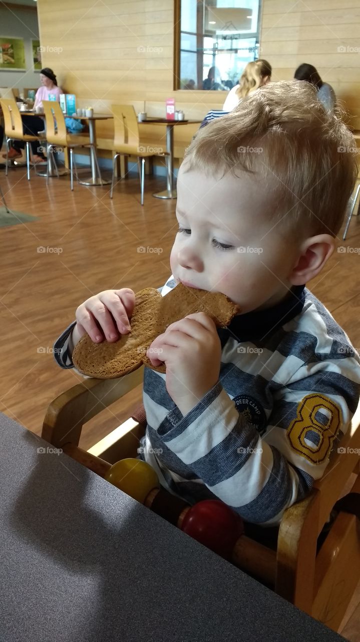Boy eats tasty biscuit