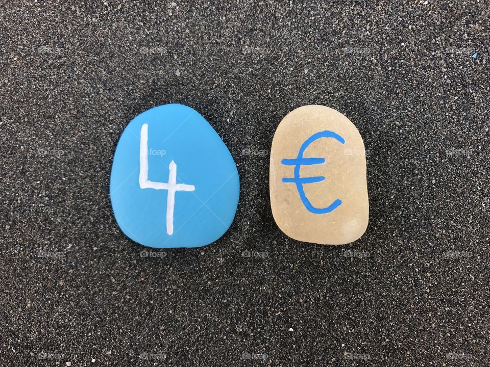 4 Euro with colored stones over black volcanic sand