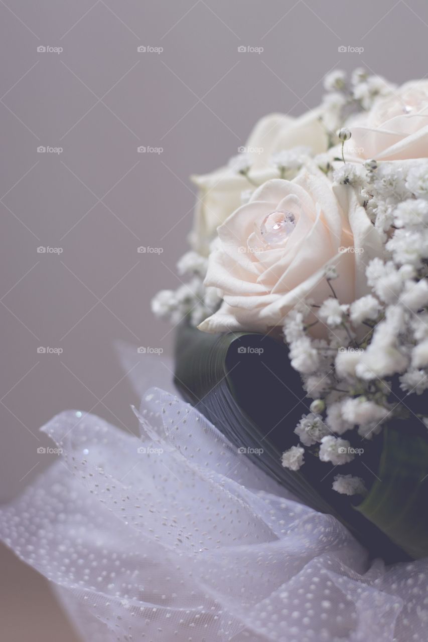 closeup shot of wedding bouquet. close up of wedding bouquet of white roses with crystals on them 