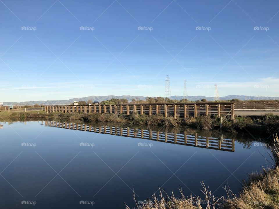 Fence reflection in the bay water