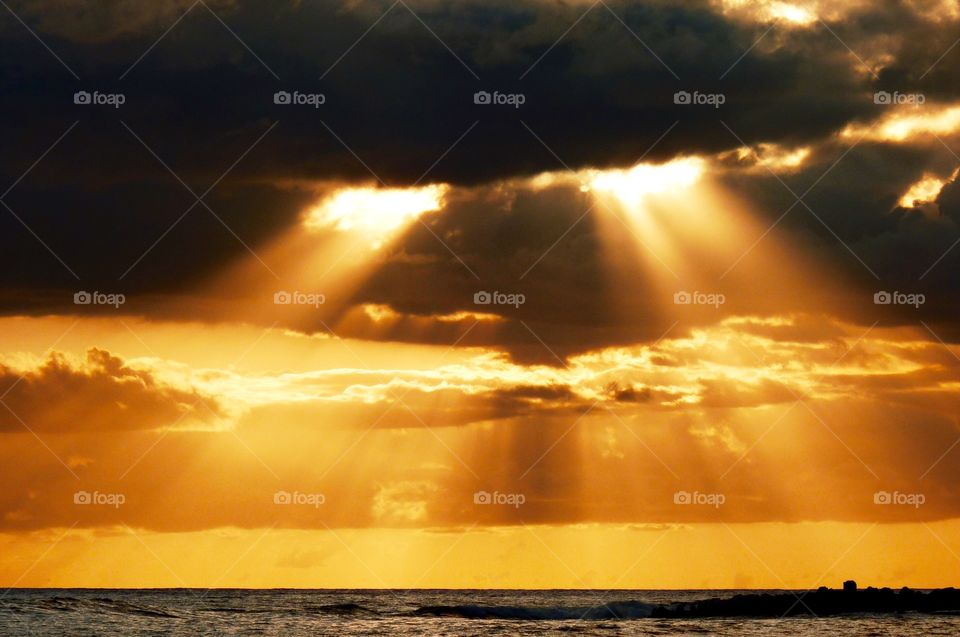 Sunlight illuminates through clouds over the Pacific Ocean 
