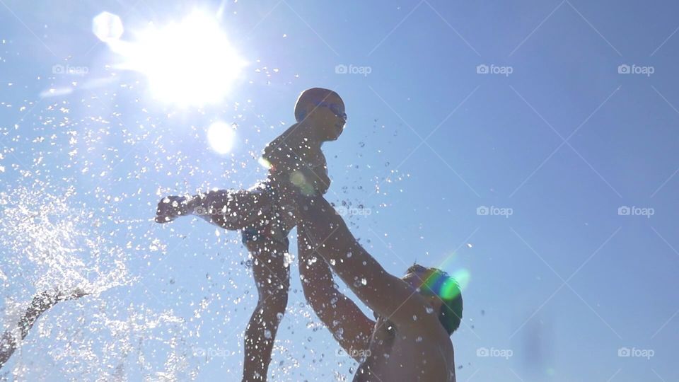 baby sea.  Dad tosses baby son up in the rays of the sun. family vacation by the sea