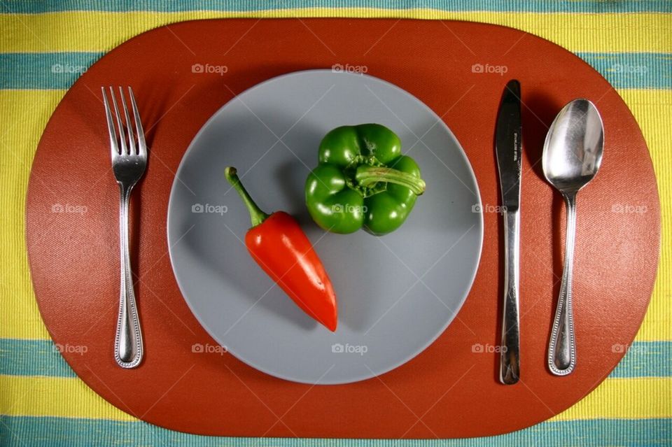 Red and green bell pepper on a plate setting