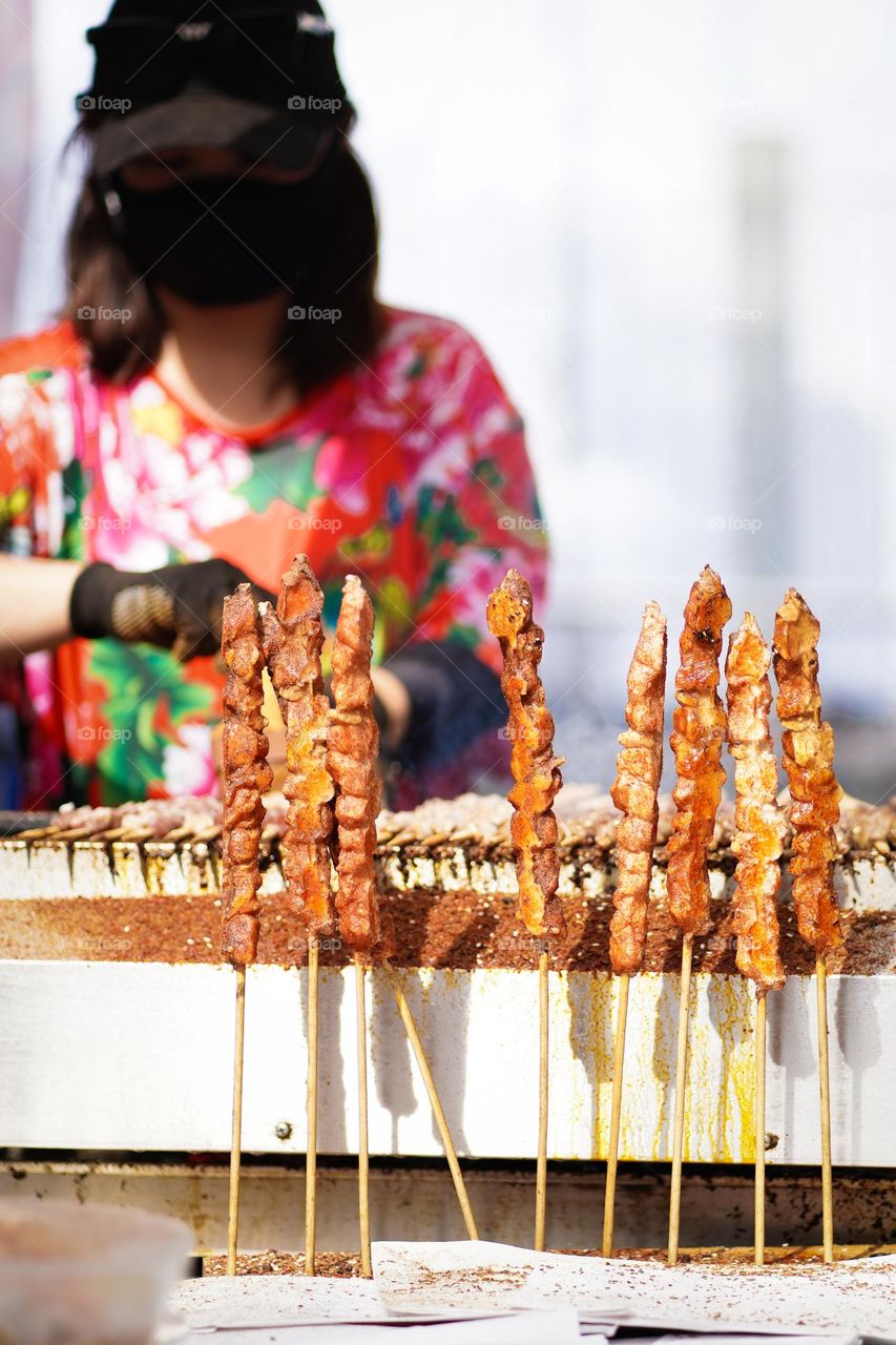 japanese lady making barbeque skewers