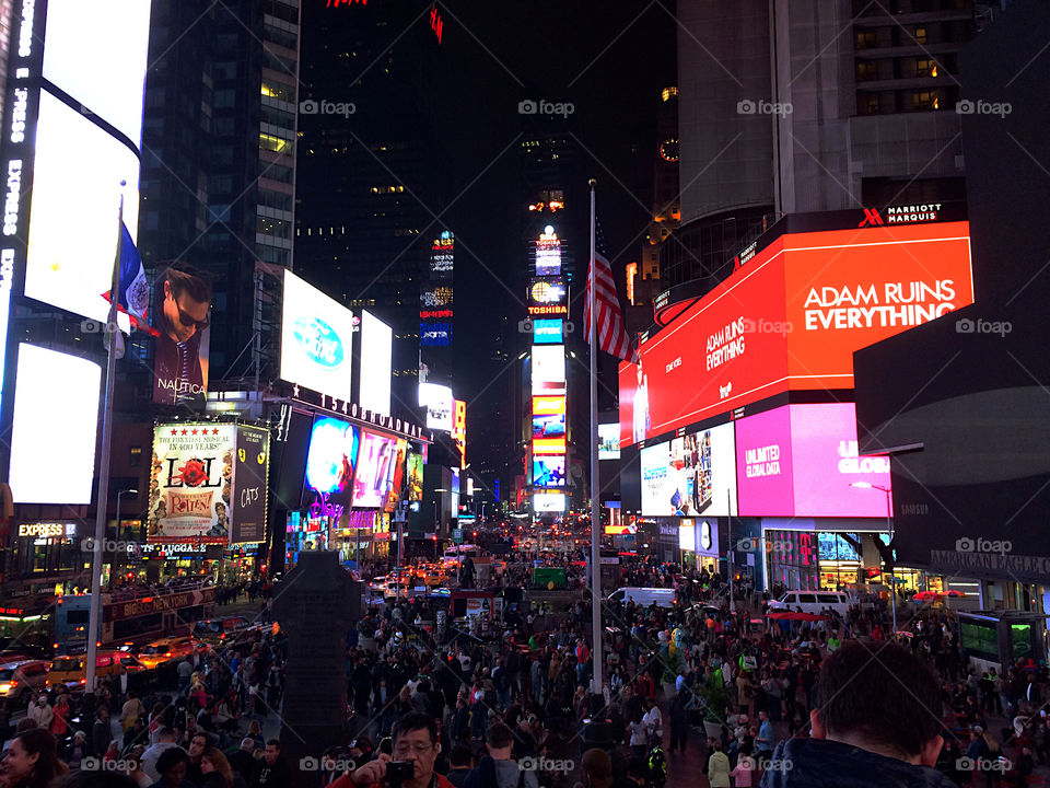 Times Square is crowded at night with tourists