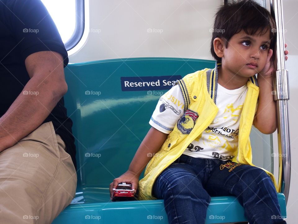 young child sitting inside a train