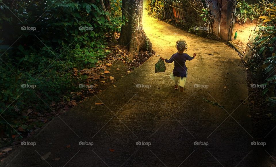 A little girl happily going to her grandmother home with fruits