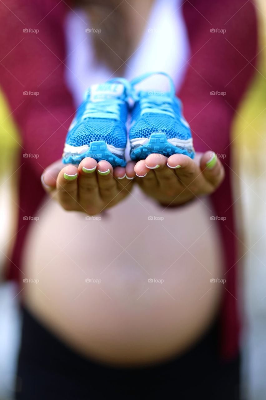 Pregnant holding a little shoes