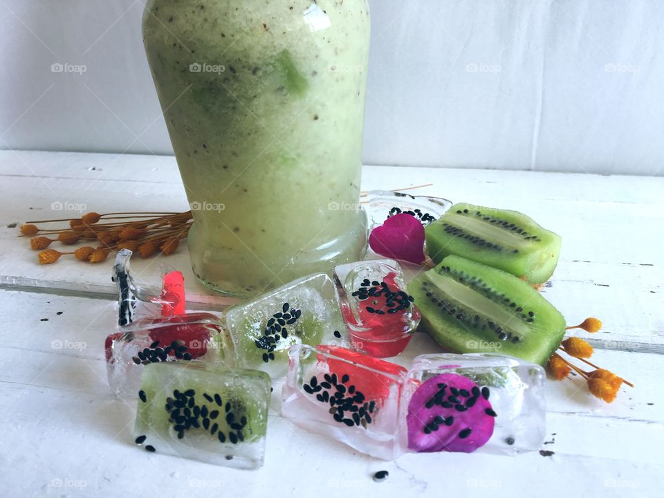 Kiwi juice and aromatic ice with fruit and flower petals