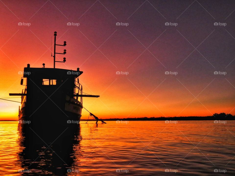 Lonely boat on his way to the sunset.