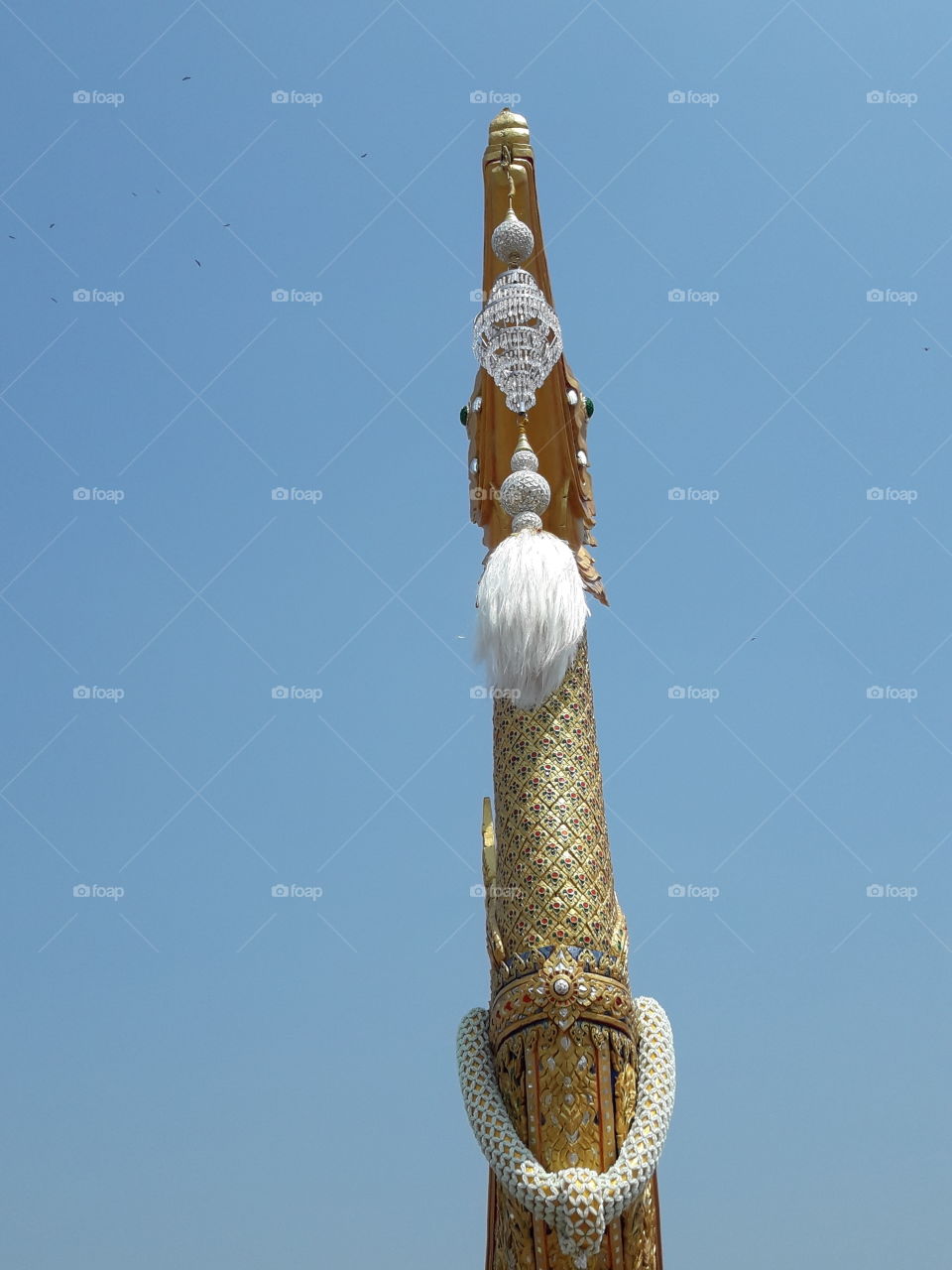 view at below directly to the hamsa's mouth which see the crystalline ball , the dangling tassels also carved pattern with gilded lacquer and mirrored glass decoration on its neck.