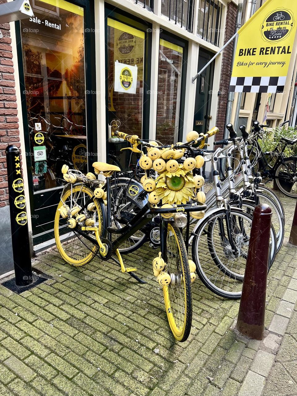 In the photo, a yellow bicycle is decorated with flowers and emoticons 