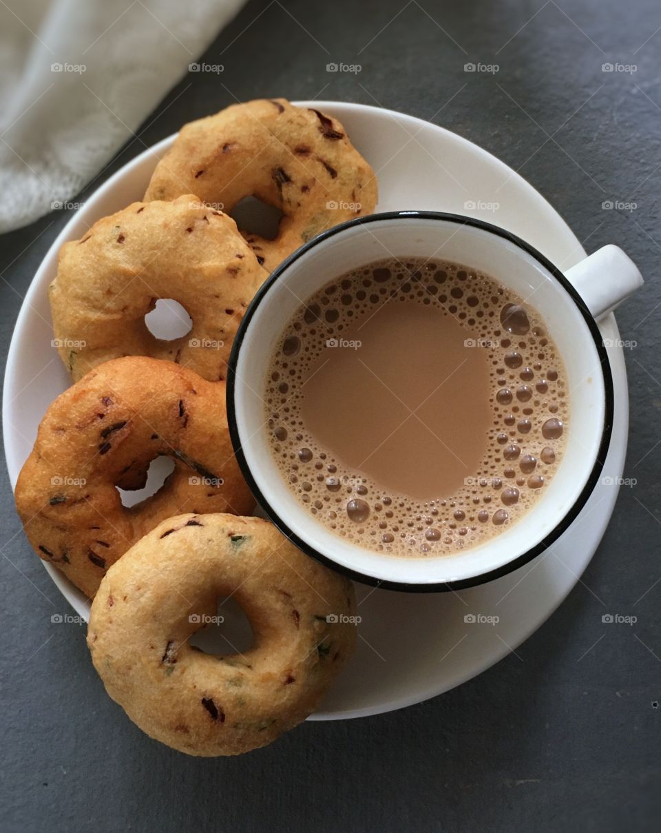 Delicious Medhu vadai with a cup of milk tea .