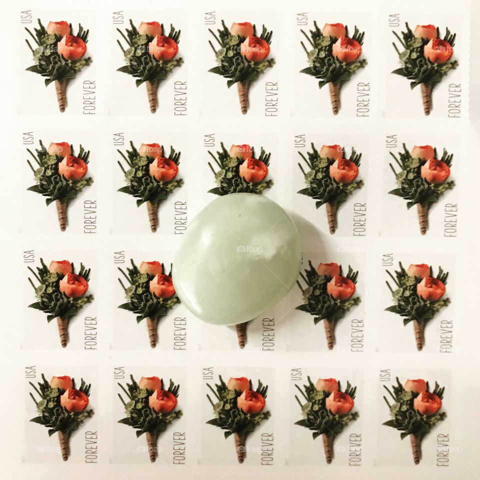 Classic flower stamps beneath a light green Jade crystal.