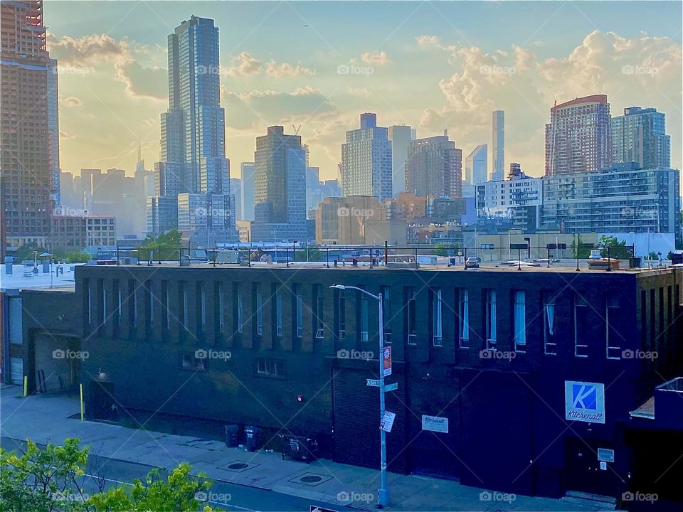 This is the view from the staircase of the „Pulaski Bridge“ on the „Greenpoint“, Brooklyn side at about half level onto a factory building nearby, LIC, Queens and further back „Manhattan“. 2023. Hypnotic Productions