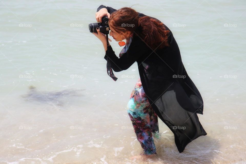 Adventurous pretty photographer captures the moment in the beautiful sea