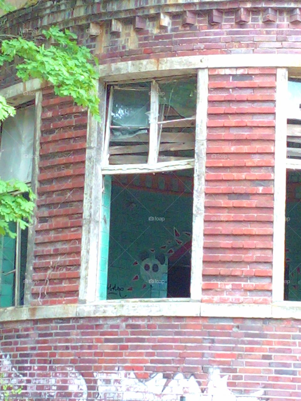 Abandoned place, window closeup with graffito