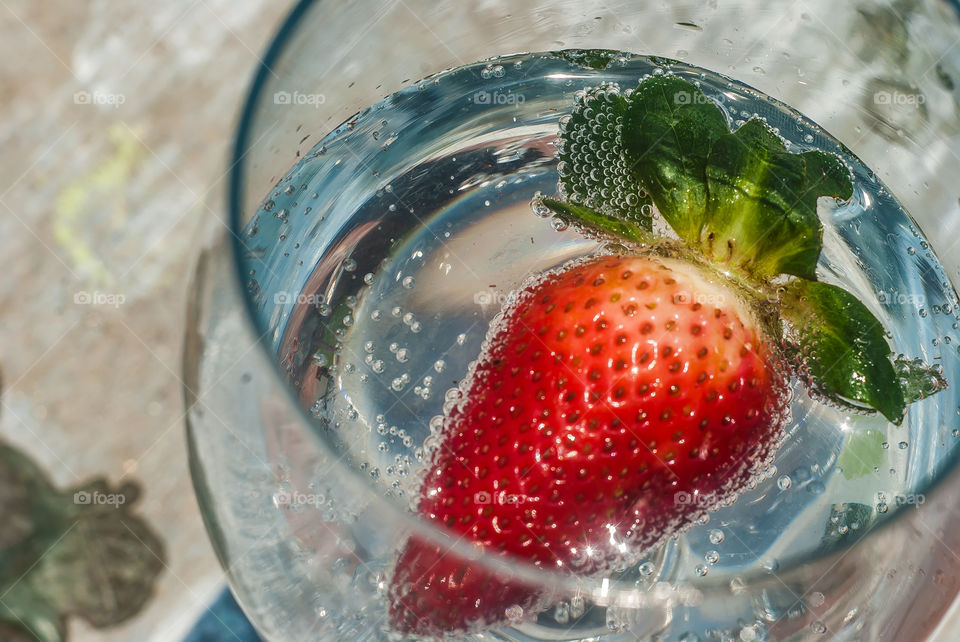 Strawberry on glass of water