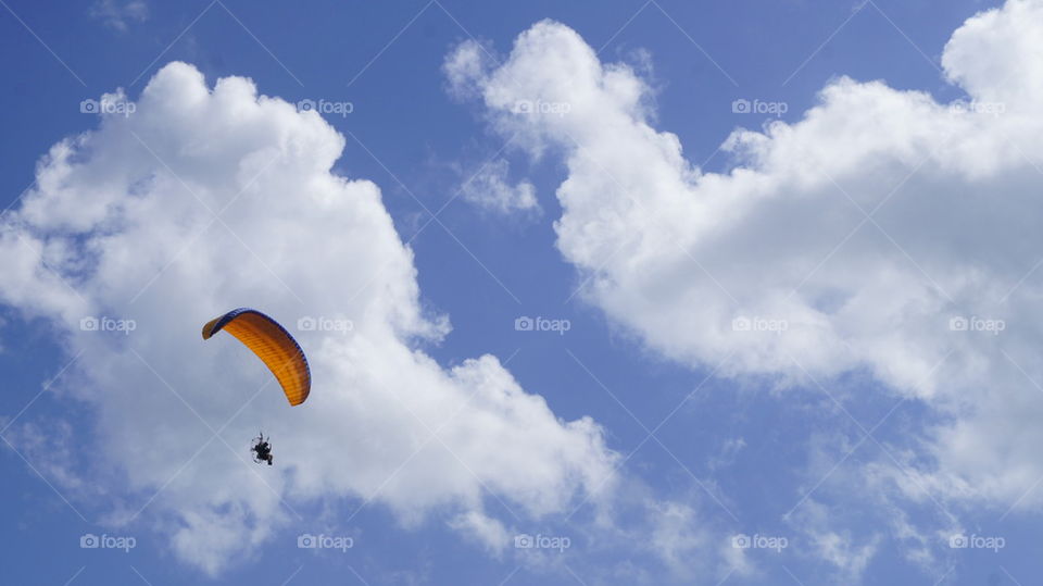 Man flying a paramotor in a cloudy sky
