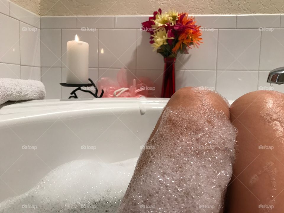 Woman taking a bubble bath with lots of bubbles.