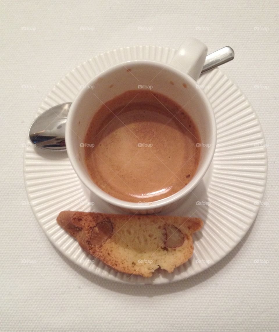 A cup of espresso with a cookie from above