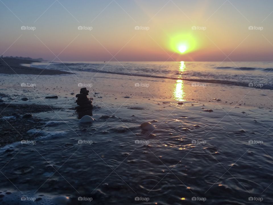 Shells and stones on a beach at sunrise