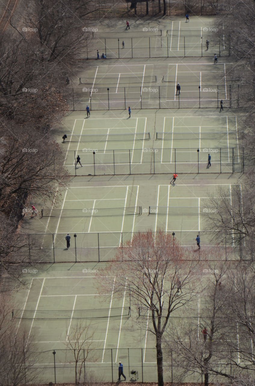 From a viewpoint high up on the George Washington bridge tennis enthusiasts can be seen getting in good days workout at Fort Washington Park of New York.