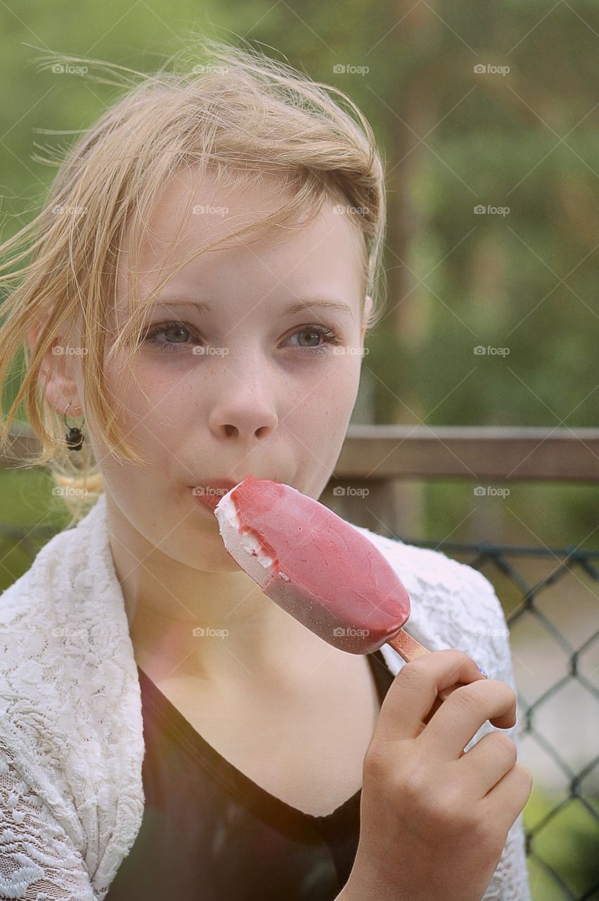 Girl eating ice cream. Girl a windy day eating ice cream in the park