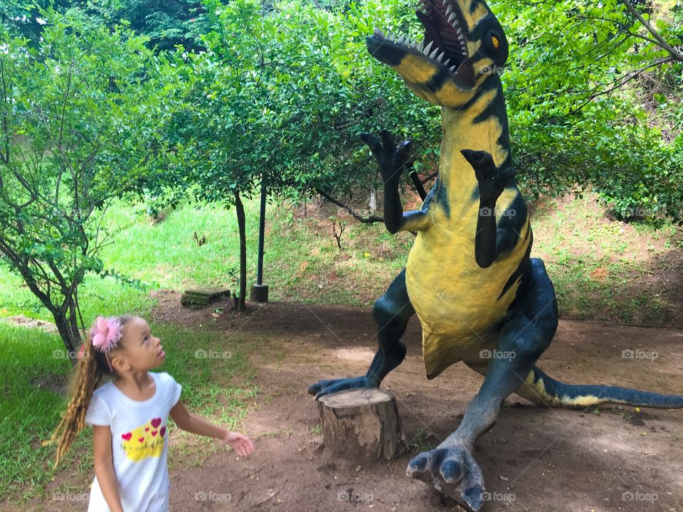 Girl at park with dinasour doll