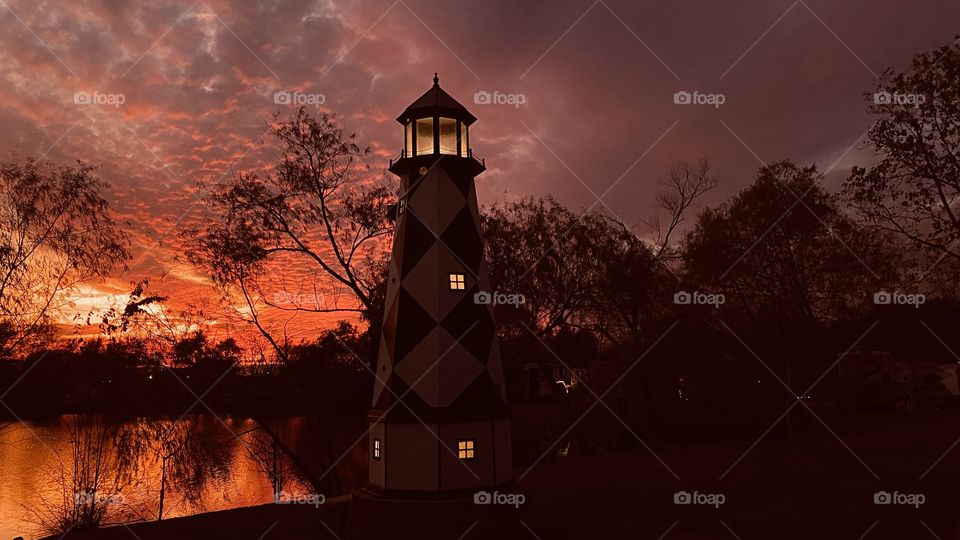 This Lighthouse is the Center of Attraction with a Fiery Sunset To Twilight setting with color palette of orange, Reds, blue-Gray Backlit Features to make A Gorgeous End to a Glorious Day. 